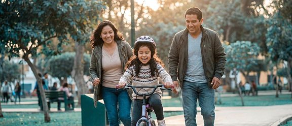 Familia acompañando a su hijo montando bicicleta, simbolizando la amplia cobertura de multisalud