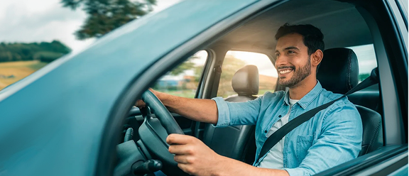 Hombre conduciendo feliz, simbolizando la plenitud que produce la cobertura de seguro de auto