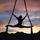 Silueta de persona estirándose en el atardecer.