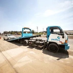Grúa de Pacífico Seguros llevando un automóvil asegurado con seguro vehicular auto efectivo